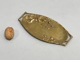 a gold plate with a walnut on it next to it