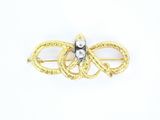 un gros plan sur une broche en or et diamants