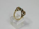 a close up of a gold ring with a green stone on it
