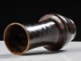 a vase that is sitting on a table with a black background