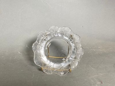 a small glass plate with a gold handle on a table