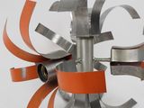 an image of a metal sculpture with orange ribbons