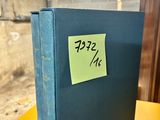 a blue book with a sticker on it sitting on a yellow table
