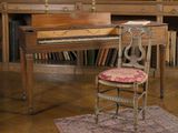 un piano et une chaise devant une bibliothèque