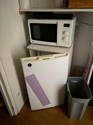 deux micro-ondes et une poubelle dans la cuisine