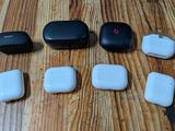 four airpods sitting next to each other on a wooden table