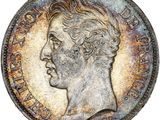 un gros plan d'une vieille pièce de monnaie sur laquelle figure le visage d'un homme