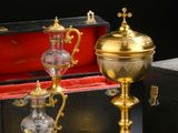 two gold - plated cups and a tray are sitting on a table