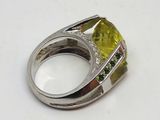 bague en argent sertie d'une pierre jaune entourée de diamants verts et blancs