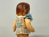 a figurine of a little girl holding a teddy bear