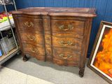 une commode en bois à nombreux tiroirs dans une pièce