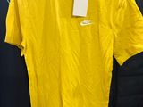 a yellow nike shirt hanging on a rack in a store