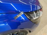 a close up of a blue car with a sticker on it