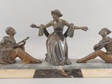 une image représentant une statue en bronze de trois femmes assises sur un socle en marbre