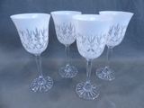 four wine glasses with etched designs on them sitting on a table
