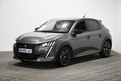 une voiture grise est garée dans une pièce au sol à carreaux