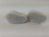 two white rocks sitting on a white surface