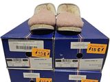 Des boîtes de chaussures sont empilées les unes sur les autres sur un fond blanc