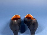 pair of black leather shoes on a blue background
