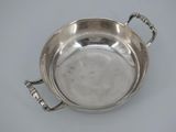 an antique silver plate with handles and handles on a table