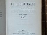 un vieux livre posé sur une étagère en bois, à côté d'une pile de livres