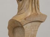sculpture of a woman ' s head on a wooden stand