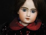 a close up of a doll on a black background with a black background