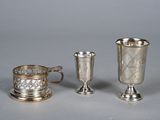 two silver cups and a silver cup on a table