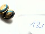 une paire de boucles d'oreilles bleues et dorées posées sur un morceau de papier