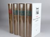 four books in a row on a white surface with a gray background