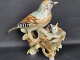 a figurine of a bird sitting on top of a tree branch