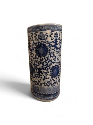un vase bleu et blanc posé sur une surface blanche