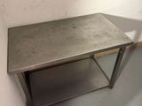 a small table with a metal top in the corner of a room