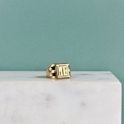 the gold ring is sitting on top of a white marble block