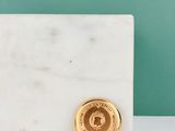 une pièce d'or posée sur un bloc de marbre blanc