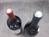 two bottles of wine sitting next to each other on a sink