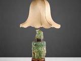 une lampe surmontée d'un abat-jour vert