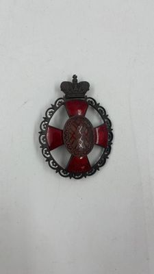 une image représentant un insigne rouge et noir orné d'une couronne