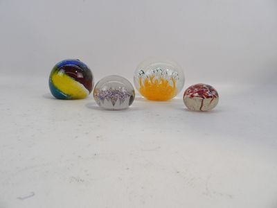cinq billes de verre posées sur une surface blanche