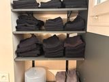 many folded towels on the shelves in the closet