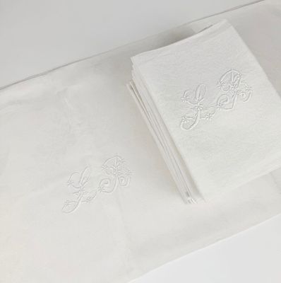 two white towels sitting on a white table with a pair of scissors