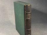 an old book sitting on top of a table next to a gray background