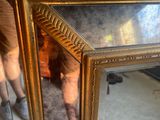 a mirror that is sitting on the floor in front of a person