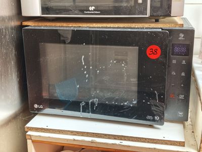 deux micro-ondes posés l'un sur l'autre sur une étagère