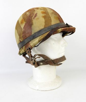 un vieux casque posé sur la tête d'un mannequin, sur fond blanc