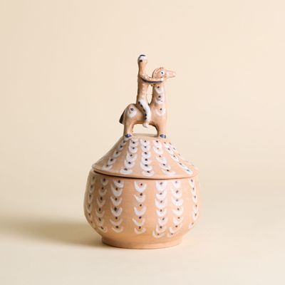 un petit animal en céramique posé sur un bol