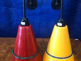 une paire de lampes coniques rouges, jaunes et bleues posées sur une table en bois
