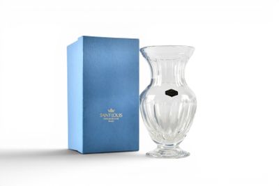 the glass vase is next to a blue box on a white surface