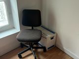 a black office chair sitting in front of a window