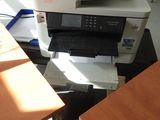 un chat assis sur un bureau, à côté d'une imprimante
